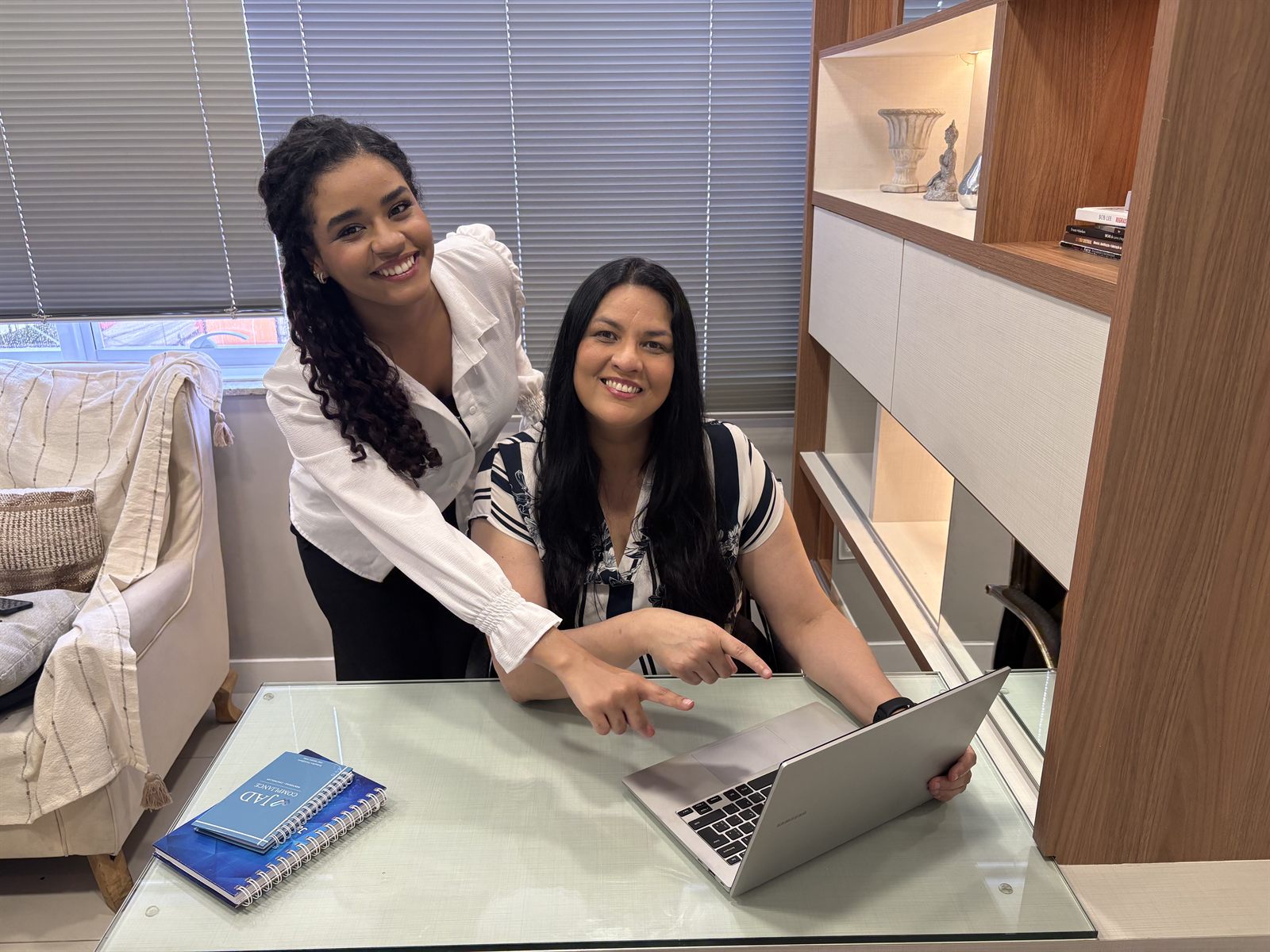 Ester e Simone diante do notebook, no escritório da JAD Compliance